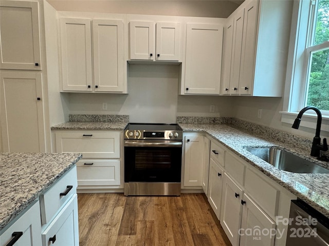 kitchen featuring white cabinets, stainless steel appliances, light stone counters, and sink