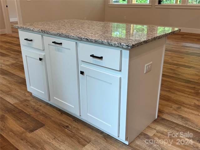 details with white cabinets, light stone counters, and light hardwood / wood-style flooring