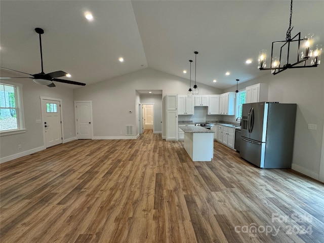 kitchen featuring stainless steel refrigerator with ice dispenser, ceiling fan with notable chandelier, pendant lighting, light hardwood / wood-style floors, and white cabinetry