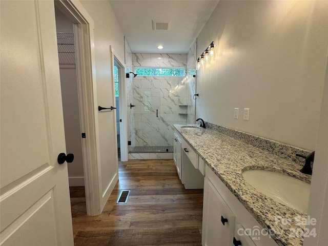 bathroom featuring vanity, wood-type flooring, and walk in shower