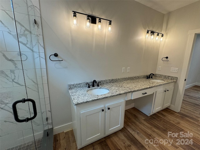 bathroom with wood-type flooring, vanity, and a shower with shower door