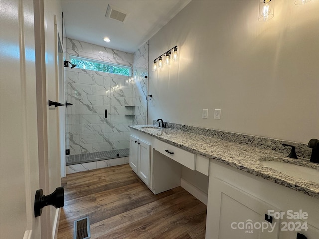 bathroom featuring hardwood / wood-style flooring, vanity, and a shower with door