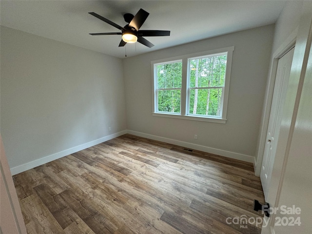 unfurnished bedroom featuring a closet, light hardwood / wood-style flooring, and ceiling fan