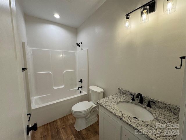 full bathroom with bathing tub / shower combination, toilet, vanity, and hardwood / wood-style flooring