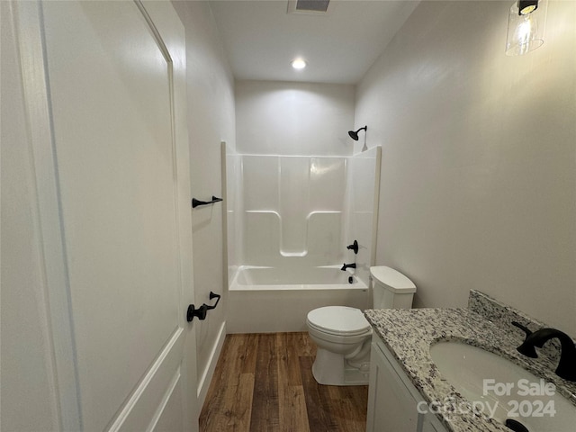 full bathroom with hardwood / wood-style flooring, vanity, toilet, and shower / tub combination