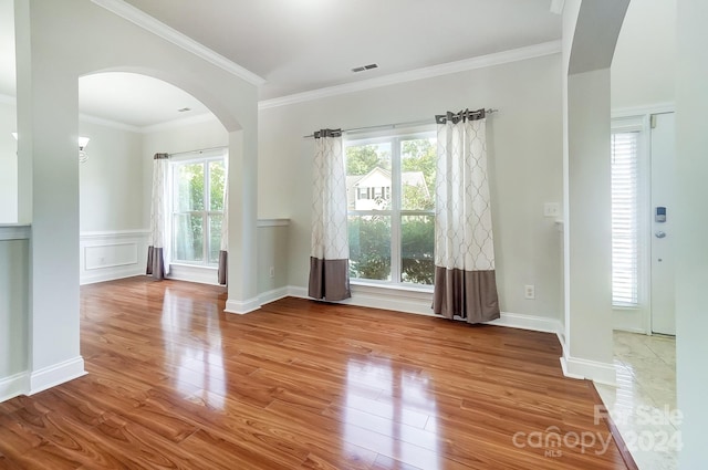 empty room featuring crown molding and light hardwood / wood-style flooring