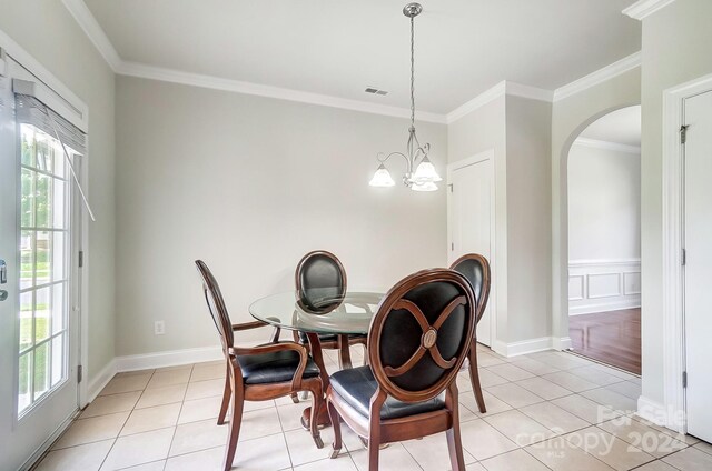 dining space featuring ornamental molding and light tile patterned floors