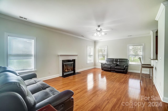 living room with crown molding, light hardwood / wood-style flooring, and ceiling fan