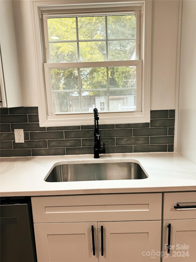 kitchen with dishwasher, sink, white cabinets, and a healthy amount of sunlight