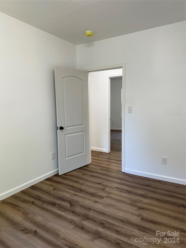 spare room with dark wood-type flooring