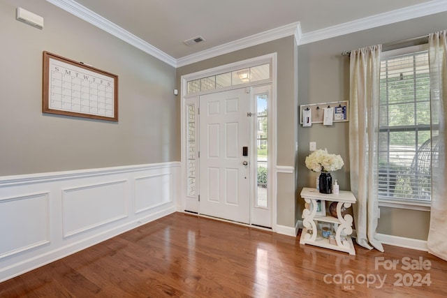 entryway with ornamental molding, a healthy amount of sunlight, and wood-type flooring