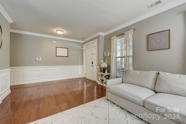 living room with hardwood / wood-style flooring and ornamental molding