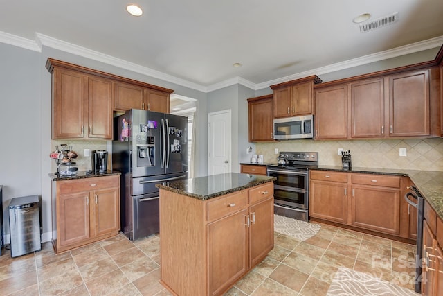 kitchen with appliances with stainless steel finishes, a center island, dark stone counters, and backsplash