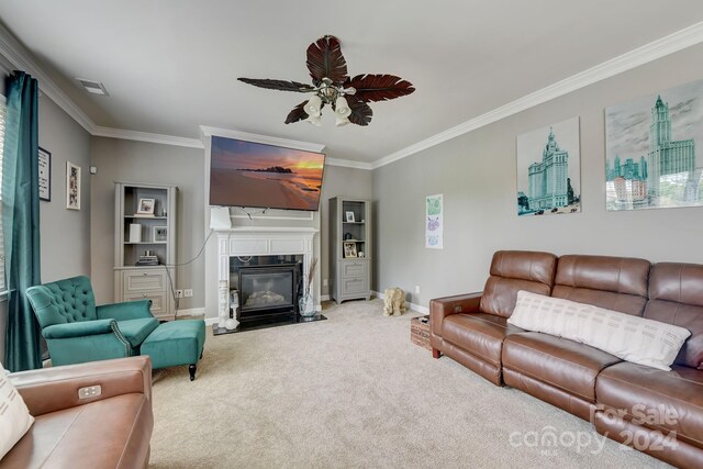 carpeted living room featuring a high end fireplace, ceiling fan, and ornamental molding