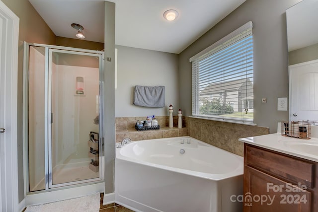 bathroom with tile patterned floors, vanity, and shower with separate bathtub