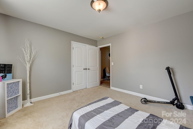 bedroom featuring light carpet and a closet