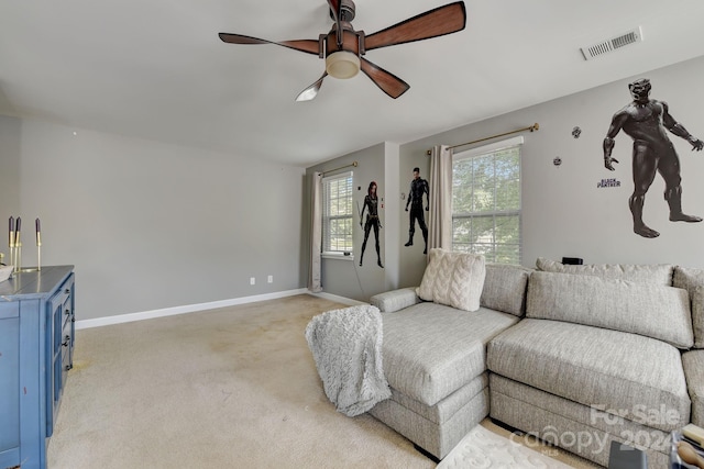 carpeted living room featuring plenty of natural light and ceiling fan