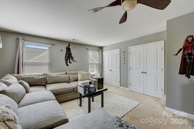 carpeted living room with ceiling fan