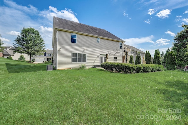 back of house with a yard and central AC