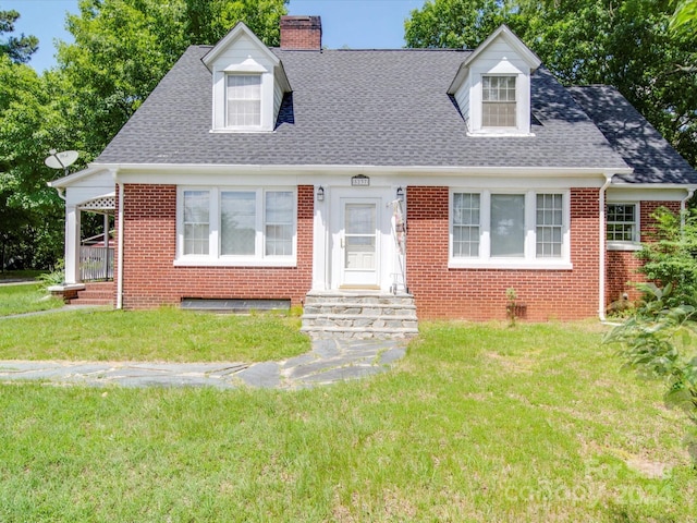 cape cod house with a front lawn