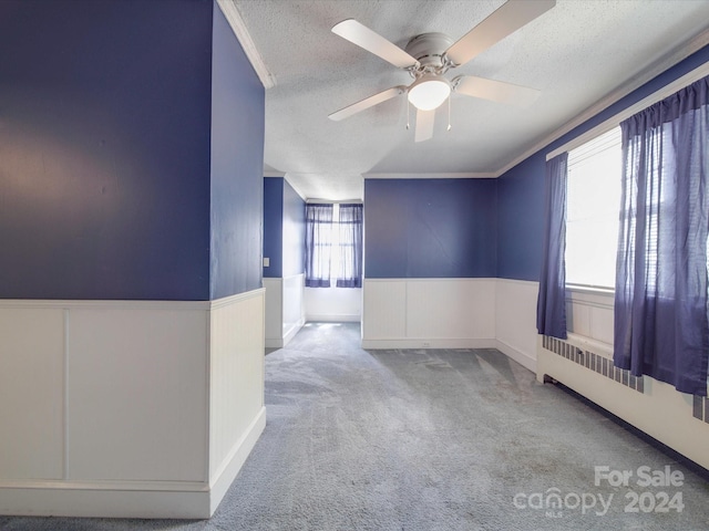 carpeted spare room featuring ceiling fan and a textured ceiling