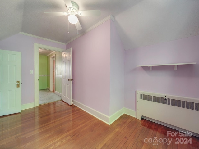 bonus room with lofted ceiling, wood-type flooring, radiator heating unit, and ceiling fan