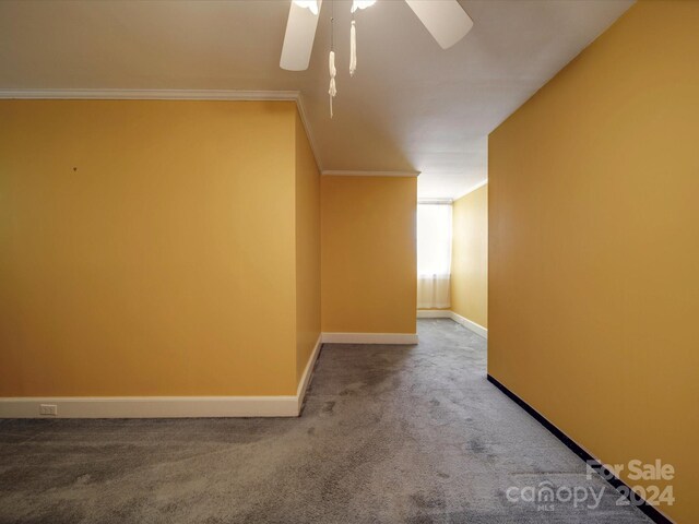 carpeted spare room featuring ceiling fan and crown molding