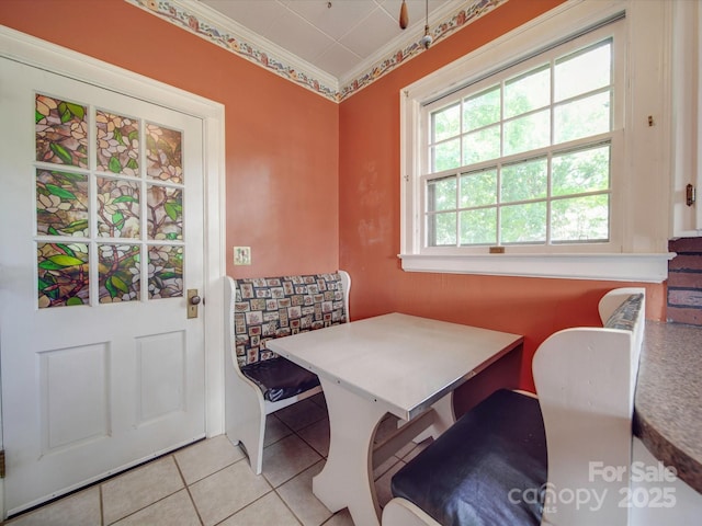 tiled dining room featuring crown molding