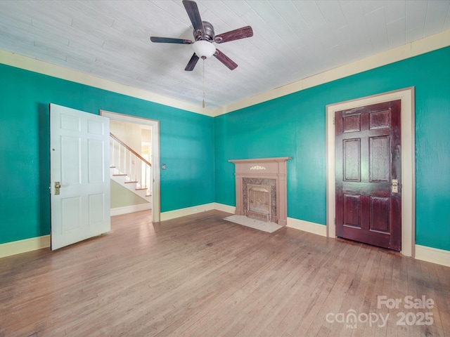 unfurnished living room featuring wood-type flooring, ceiling fan, and a high end fireplace