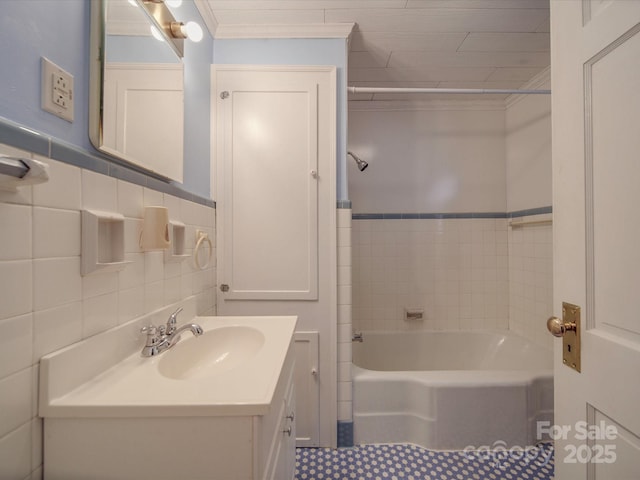 bathroom with ornamental molding, tile walls, vanity, and a tub to relax in