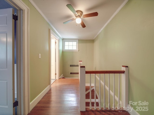 hall with hardwood / wood-style flooring, crown molding, and radiator heating unit