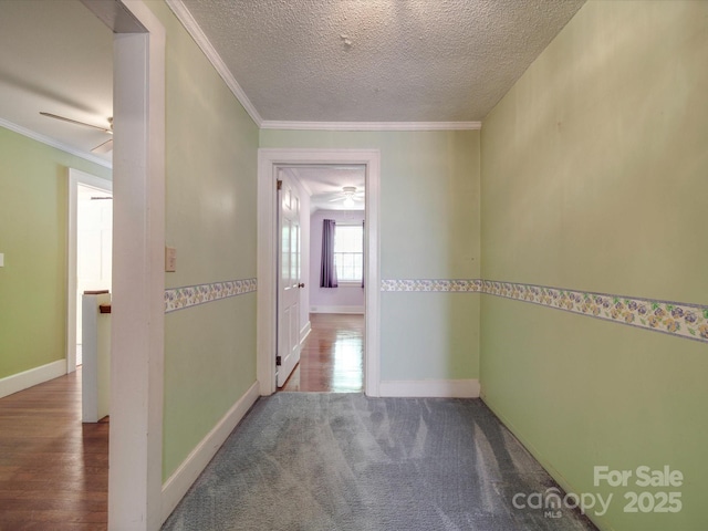 hall with carpet floors, ornamental molding, and a textured ceiling