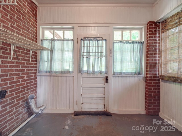 doorway to outside featuring brick wall