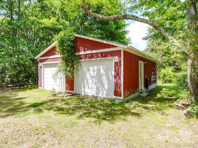 view of outbuilding with a garage and a lawn