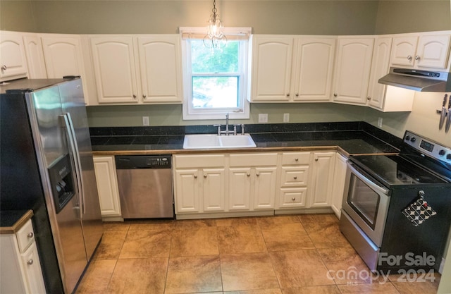 kitchen with hanging light fixtures, white cabinetry, sink, and stainless steel appliances