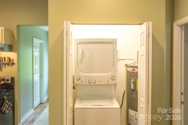 washroom featuring water heater and stacked washer and dryer