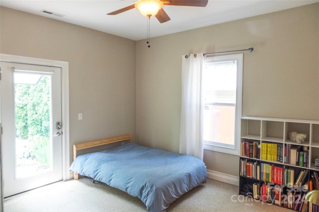 bedroom with multiple windows, light carpet, and ceiling fan