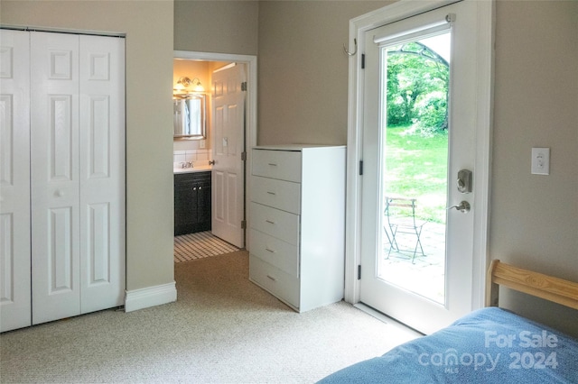 bedroom featuring ensuite bath, light colored carpet, access to outside, and a closet