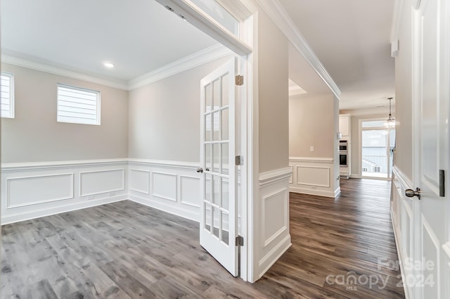 hallway featuring hardwood / wood-style floors, an inviting chandelier, and crown molding