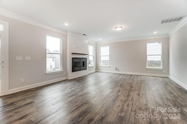 unfurnished living room featuring a large fireplace, dark hardwood / wood-style floors, and ornamental molding