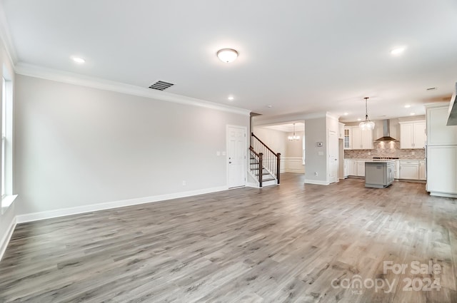 unfurnished living room featuring crown molding and light hardwood / wood-style flooring