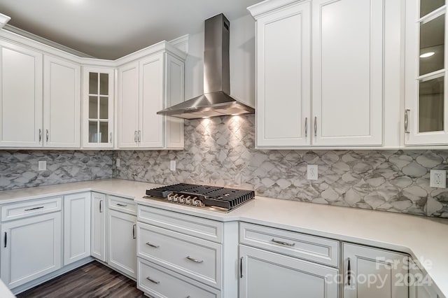 kitchen featuring tasteful backsplash, white cabinets, wall chimney exhaust hood, and stainless steel gas stovetop