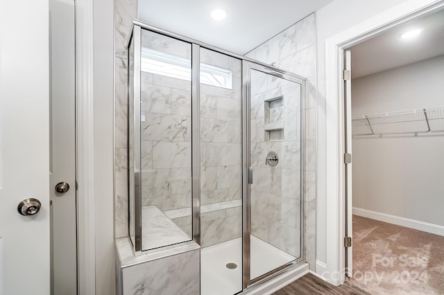 bathroom with hardwood / wood-style floors and a shower with door