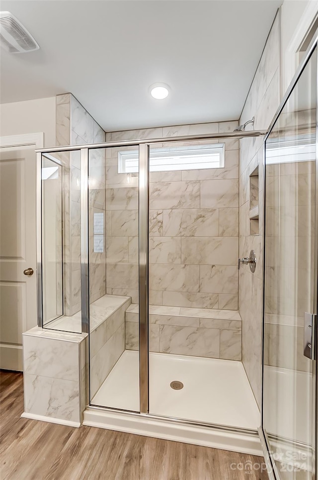 bathroom featuring hardwood / wood-style floors and walk in shower