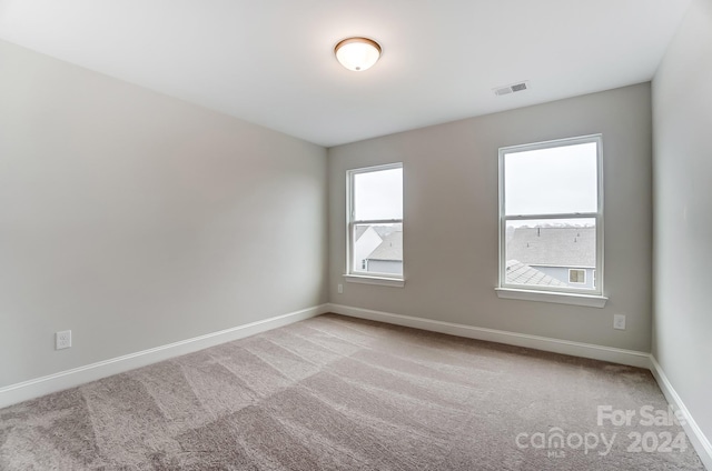 unfurnished room featuring light colored carpet