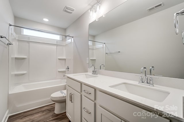 full bathroom with hardwood / wood-style flooring, vanity, toilet, and shower / tub combination