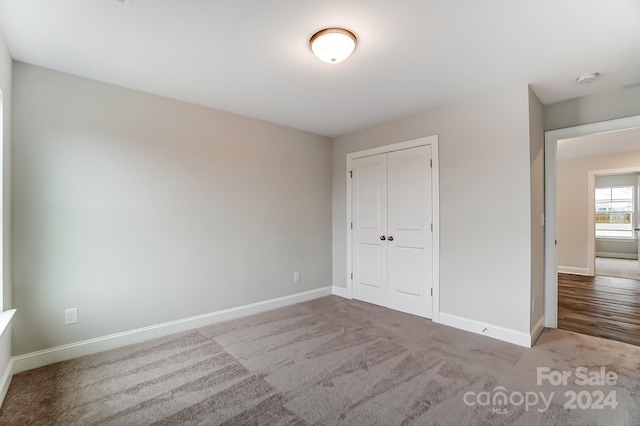 unfurnished bedroom featuring carpet and a closet