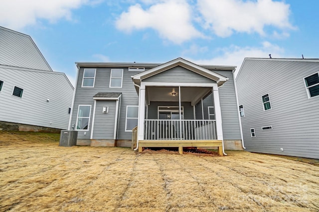 rear view of property with central air condition unit and a sunroom