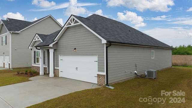 view of side of property with central air condition unit, a garage, and a lawn