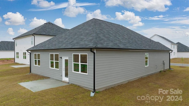 view of side of home with a patio and a yard